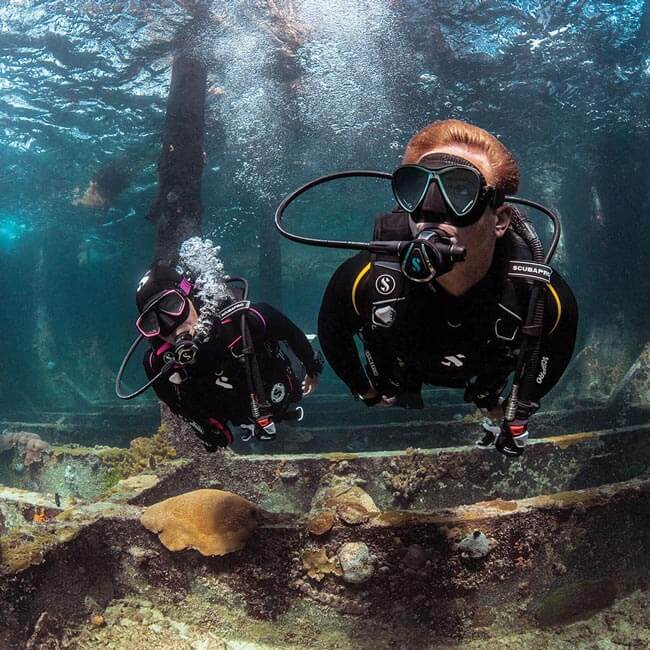 Couple scuba diving in a wreckage