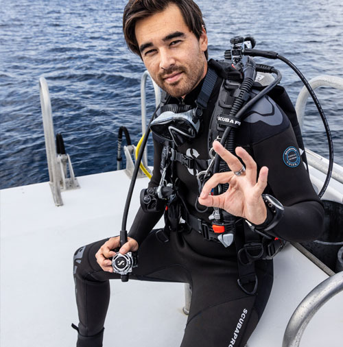 Diver sitting on a boat wearing the Hydros Pro BCD