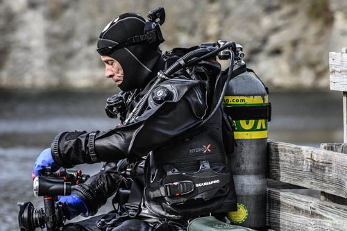 Diver wearing the Hydros X BCD sitting near water