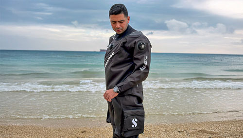 Man on sandy shore wearing a SCUBAPRO Definition Dry HD Drysuit