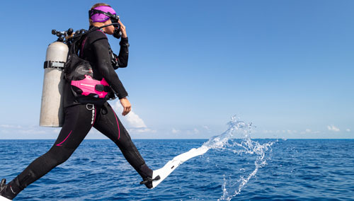 Diver in SCUBAPRO gear stepping off a boat into the ocean