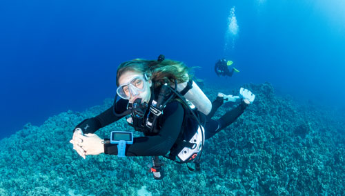 Woman underwater in the ocean wearing SCUBAPRO diving gear