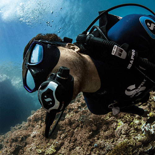 Close up of a man diving underwater wearing an Everflex 1.5mm Long Sleeve Top