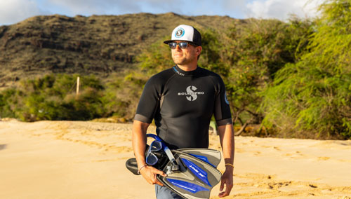 Man walking on the beach with SCUBAPRO snorkeling gear