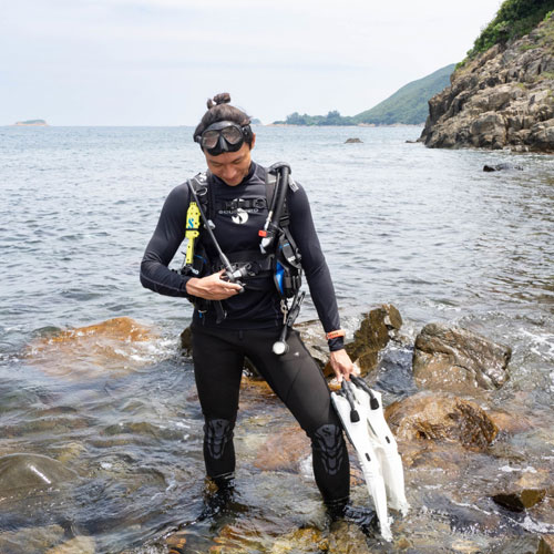 Diver standing on the rocky shore in SCUBAPRO divewear