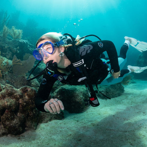 Woman diver underwater wearing a SCUBAPRO Everflex YULEX Jacket