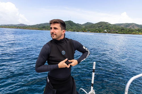 Man on a boat donning a SCUBAPRO Everflex hooded vest