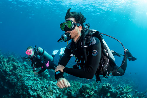 Underwater divers swimming over a coral reef