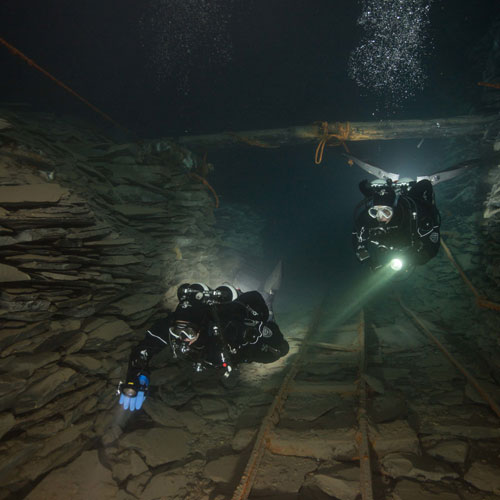 Divers underwater in the dark