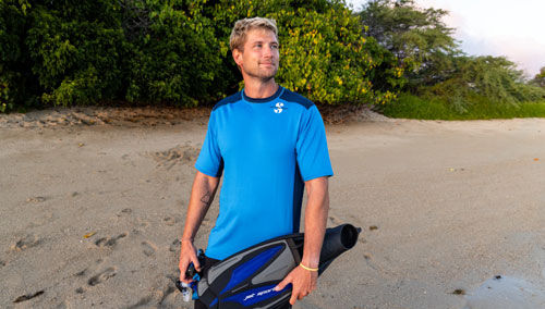 Man on the beach carrying Jet Sport full foot fins