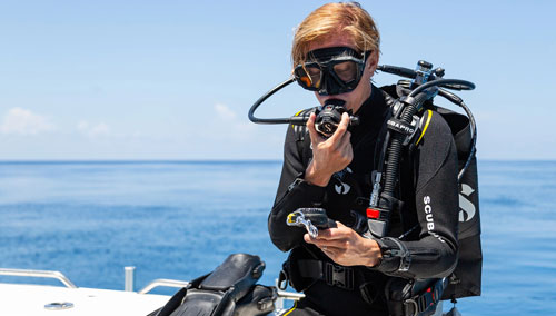 Diver sitting on side of boat wearing a SCUBAPRO Regulator System