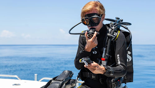 Diver on boat wearing the MK25 EVO/S620 Ti Dive Regulator System