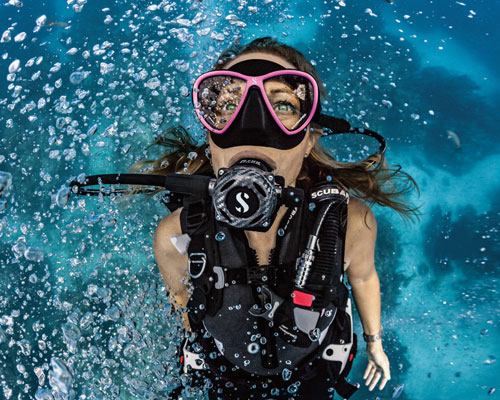 Close up of a woman diver underwater in the ocean wearing SCUBAPRO gear