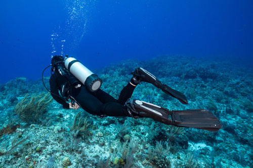 Diver wearing SCUBAPRO Seawing Supernova Fins exploring the ocean floor