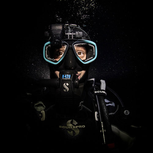 Close up of a diver underwater with black background