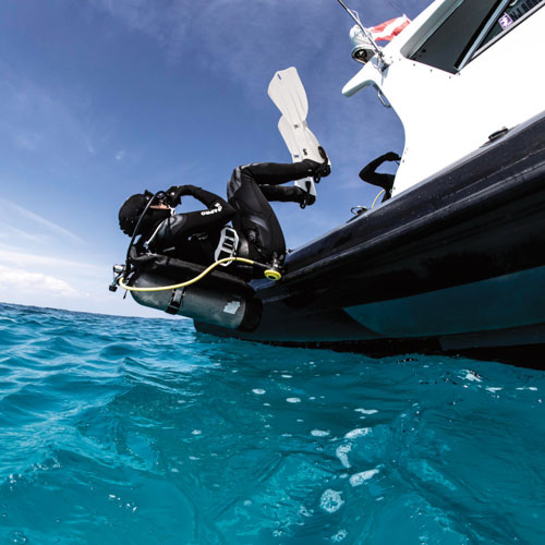 Diver doing a back roll entry off a boat