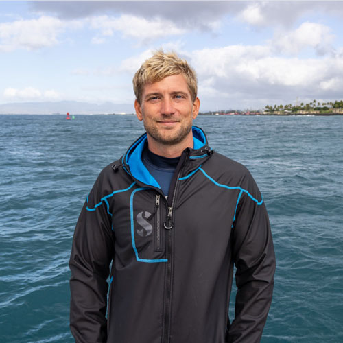  Man wearing a SCUBAPRO Cruise Coat standing with water in the background