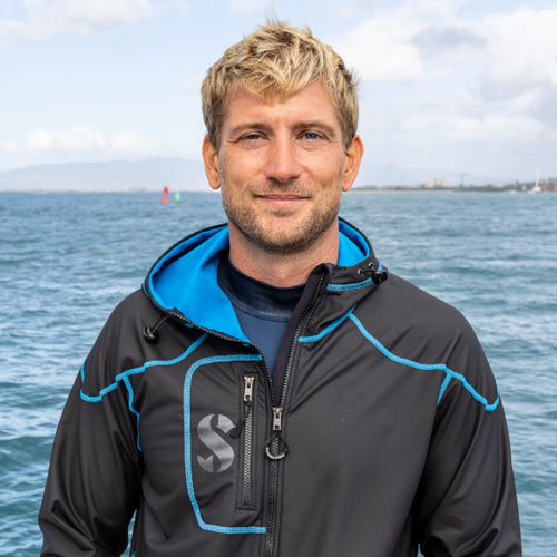 Man standing in front of water wearing a SCUBAPRO Cruise Coat