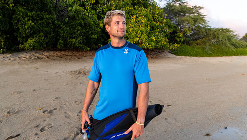 Man on beach wearing a SCUBAPRO UPF 50 Channel Flow rashguard