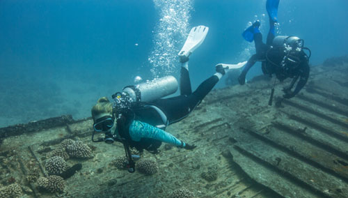 Divers wearing SCUBAPRO divewear exploring the ocean floor