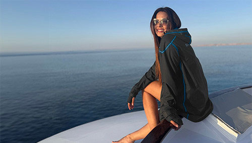 Woman sitting on a boat edge wearing a SCUBAPRO Cruise Coat