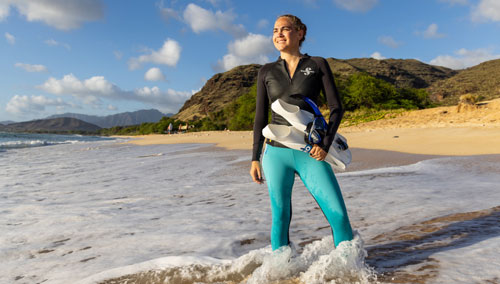 Woman in UPF 80 T-Flex Leggings standing in the surf