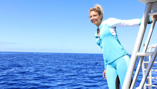 Woman leaning out off the side a a boat in SCUBAPRO divewear