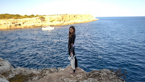 Woman standing on rocks above the water