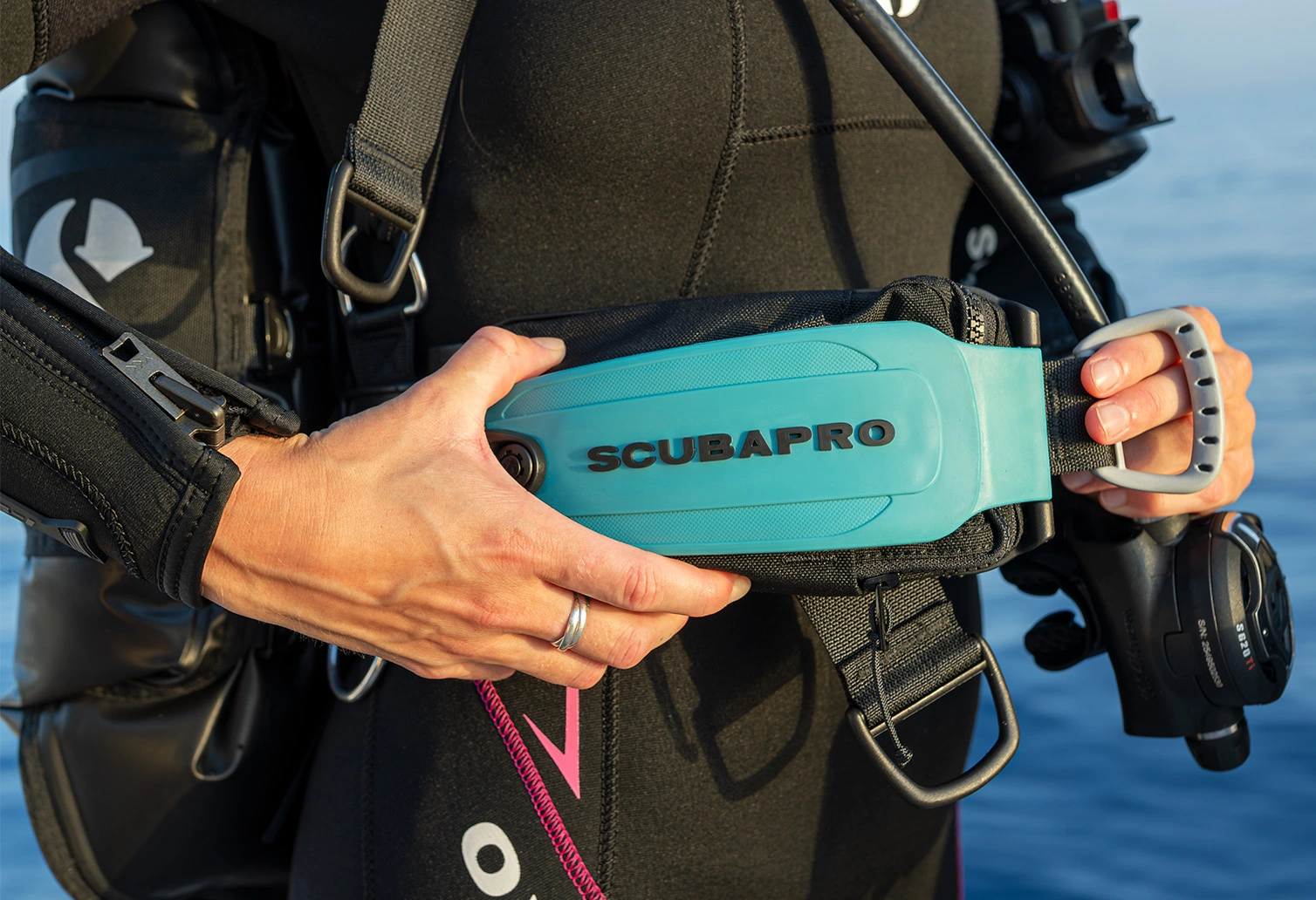 Close-up of the SCUBAPRO Hydros Pro 2 Monorail integrated weight system being inserted into the buoyancy compensator.
