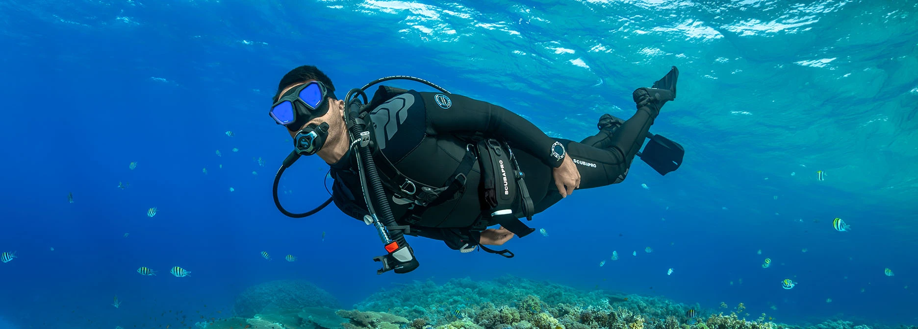 SCUBAPRO Hydros Pro 2 diver buoyancy compensator worn by a diver swimming underwater in open ocean.