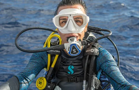Close-up of scuba diver wearing C370 White Dive Regulator with Blue Color Frame in open water