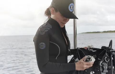 Scuba diver on boat deck checking S620 Ti White Regulator